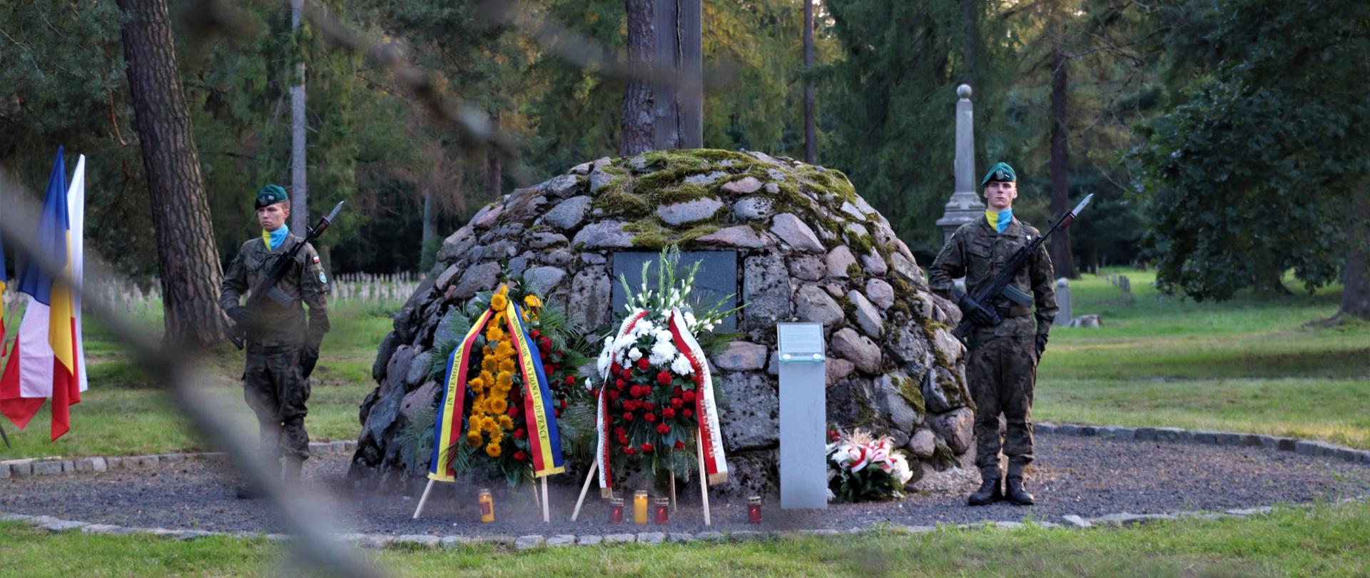 Żołnierze stojący pod pomnikiem 