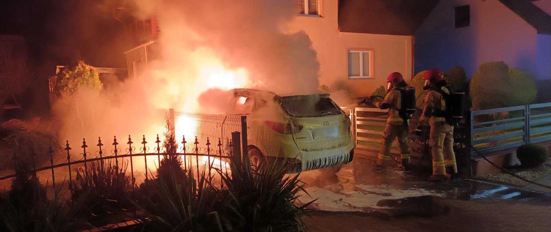 widoczne miejsce zdarzenia oraz strażacy podczas akcji gaśniczej.