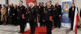 Na zdjęciu uroczyste zdanie i przyjęcie obowiązków Komendanta Powiatowego Państwowej Straży Pożarnej w Rypinie - Komendanci w trakcie ceremonii, w tle zaproszeni goście