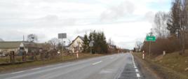 DK63 Borki - Jeże. Wjazd do miejscowości Jeże. Po lewej stronie drogi zabudowania, po prawe znak z nazwą miejscowości.