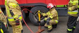 Fotografia przedstawia strażaków ćwiczących na warsztatach z ratownictwa technicznego.