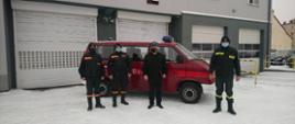Strażacy OSP i Komendant Powiatowy PSP na tle busa 9-osobowego