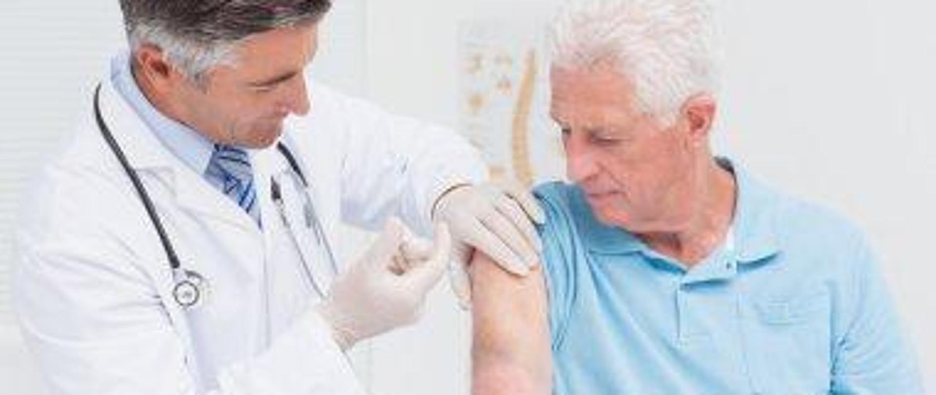 Doktor podaje szczepionkę w ramię osobie dorosłej.