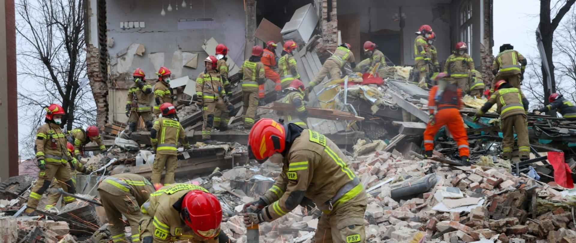 Grupa strażaków podczas działań na terenie gruzowiska