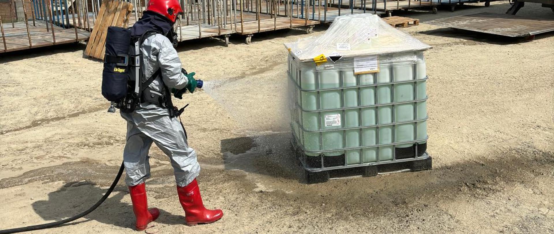 Strażak spłukuje zbiornik wodą