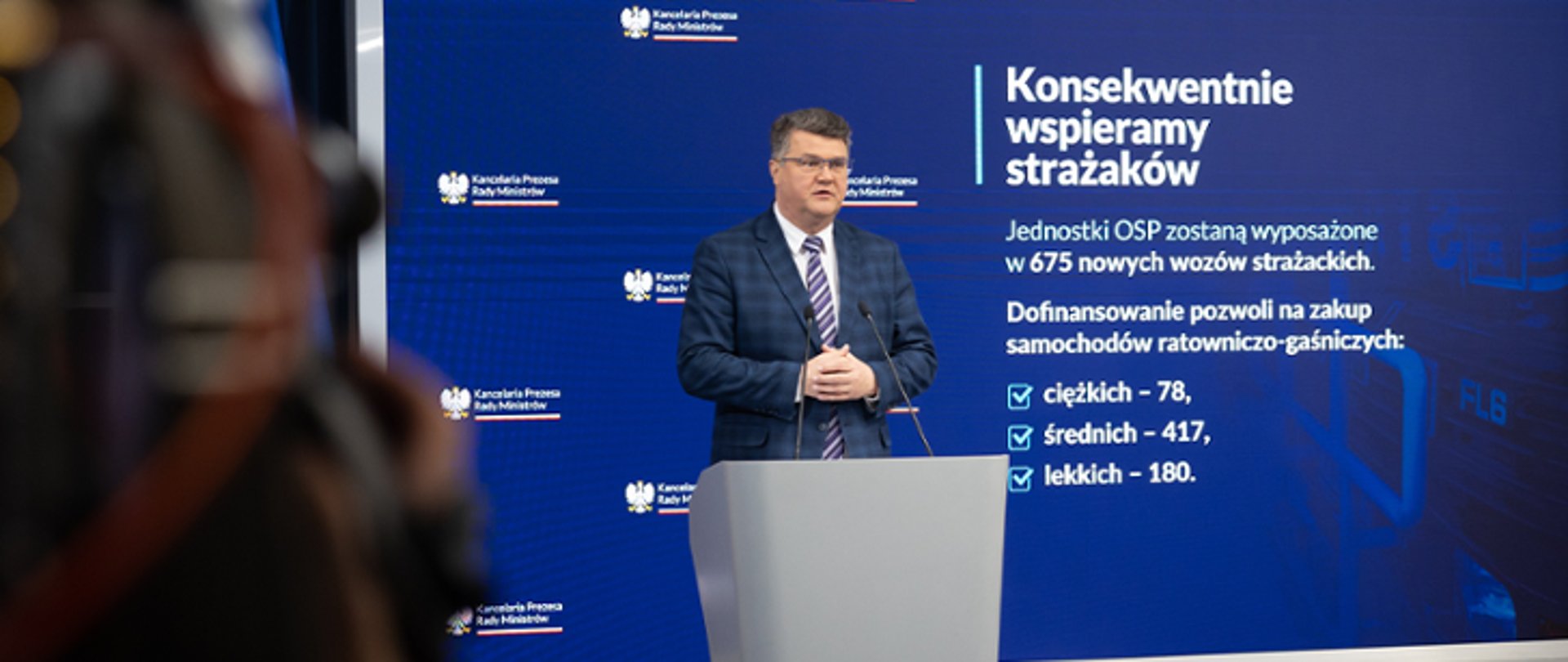 Jeden mężczyzna stojący przy mównicy i wypowiadający się