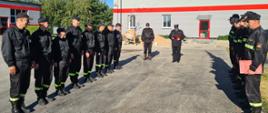 Komendant Powiatowy PSP w Złotowie mł. kpt. Tomasz Lewandowski podczas podczas czytania rozkazu. W tle Z-ca d-cy JRG st. kpt. Przemysław Jasiłek i strażacy JRG zmiany przyjmującej i zdającej służbę. 