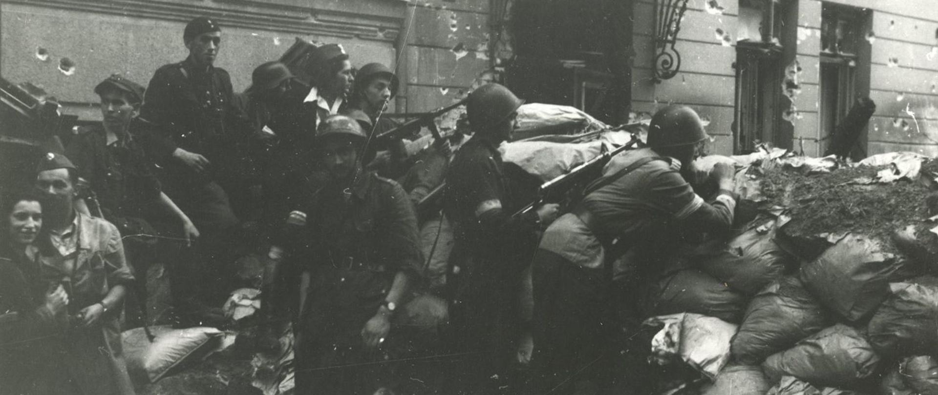 Grupa powstańców warszawskich na barykadzie.