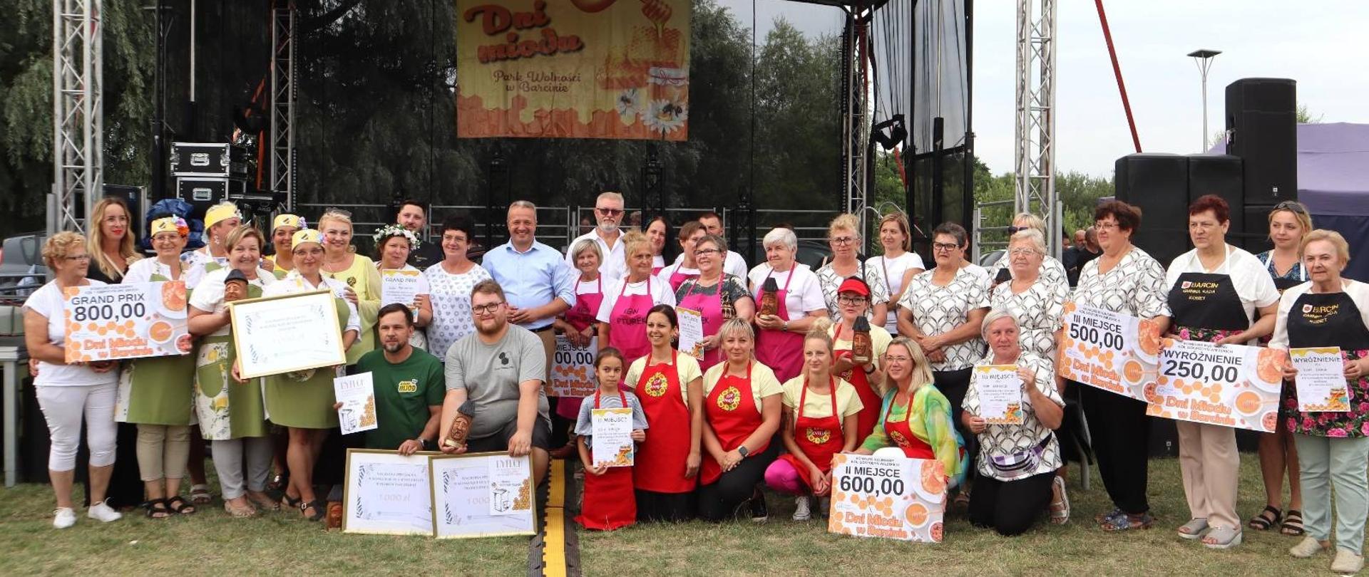 
Grupa ludzi stojąca pod sceną
