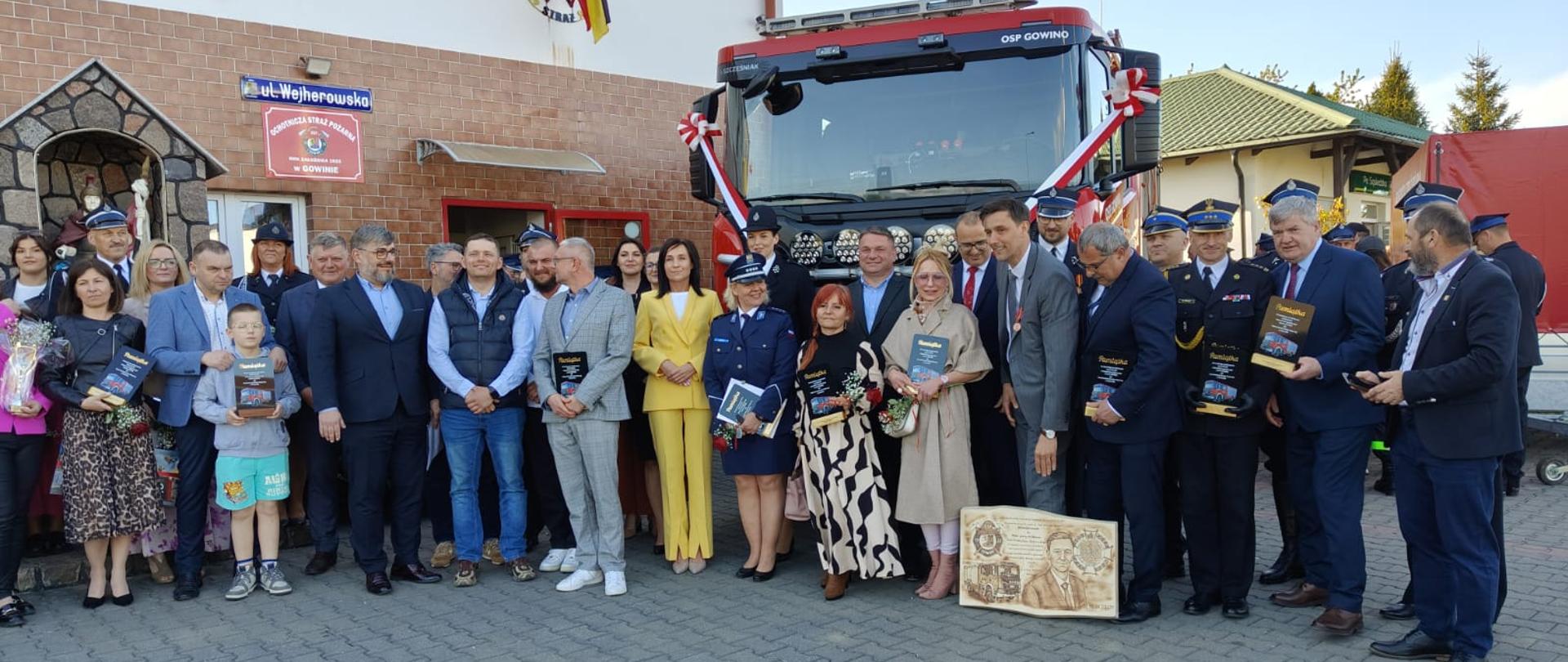 Na zdjęciu znajduje się pojazd pożarniczy i Osoby które przyczyniły się do zakupu pojazdu