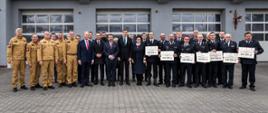 strażacy PSP, druhowie OSP, politycy i inni uczestnicy uroczystości pozują do zdjęcia na tle jednostki ratowniczo gaśniczej