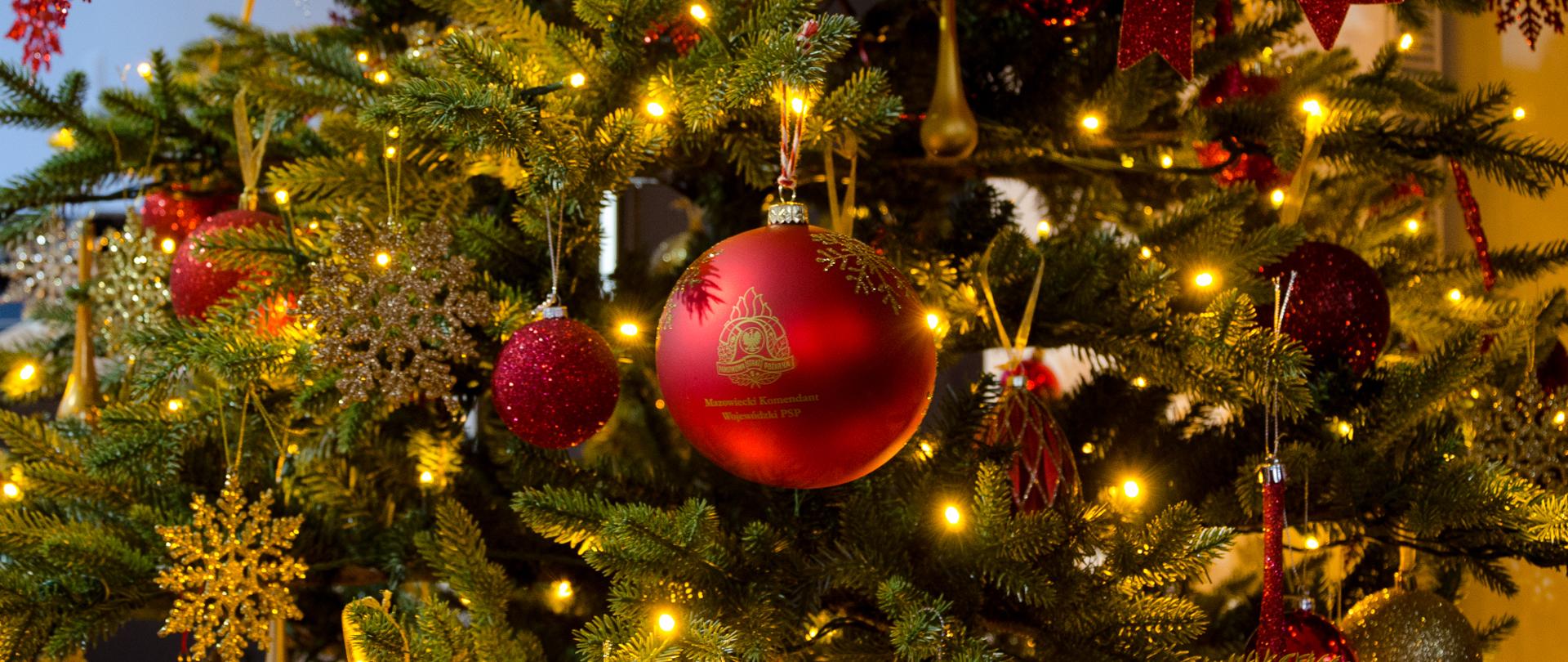 Zdjęcie przedstawia bombkę z logotypem PSP zawieszoną na choince.