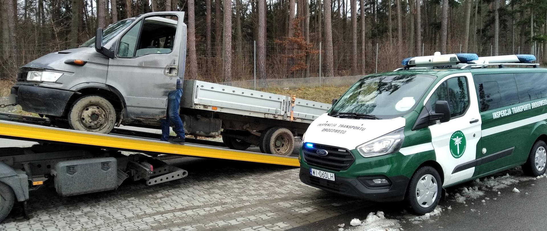 Samochód dostawczy stojący na lawecie. Obok stoi radiowóz ITD.
