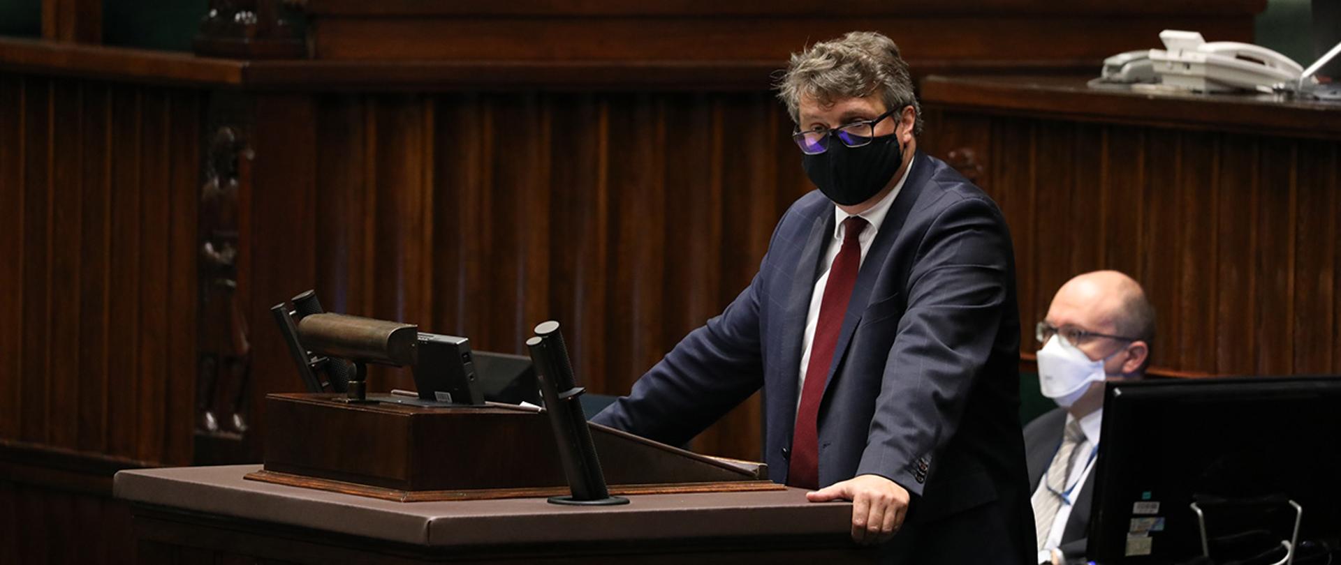 Wiceminister Maciej Wąsik widoczny ma mównicy sejmowej zabiera głos.