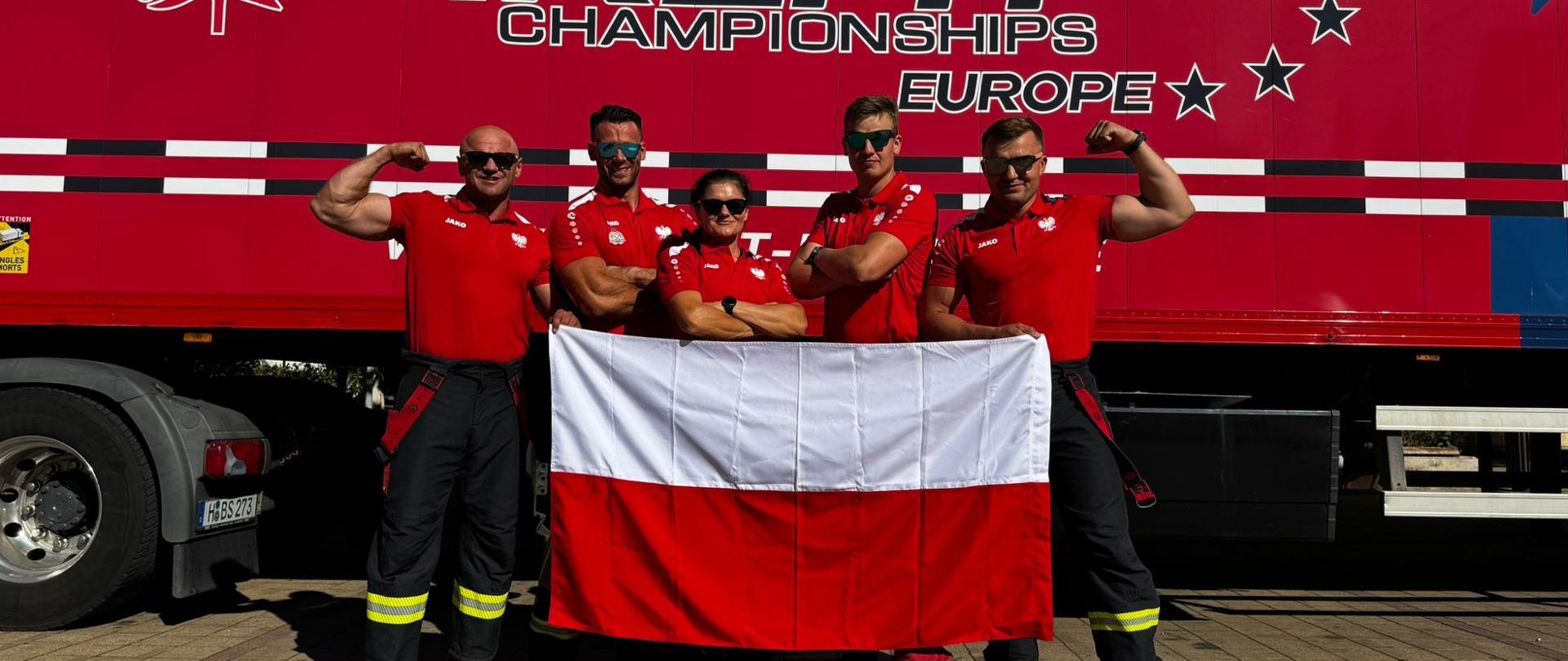 Strażacy po zwycięstwie z flagą Polski