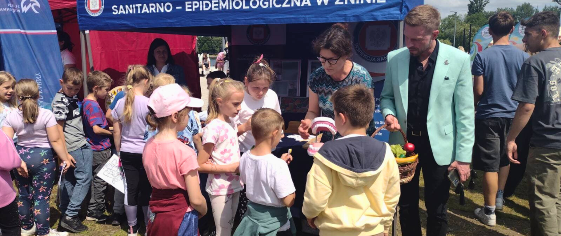 Państwowy Powiatowy Inspektor Sanitarny w Żninie z pracownikami i dziećmi podczas pikniku „Kręci mnie bezpieczeństwo latem" w Żninie.