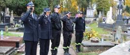Na zdjęciu strażacy salutujący nad grobami zmarłych strażaków.