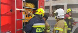 Zdjęcie przedstawia strażaków podczas szkolenia w trakcie omawiania obsługi autopompy