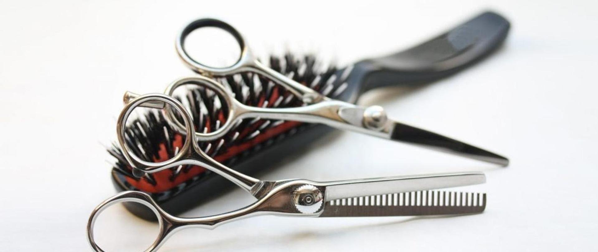 Zdjęcie przedstawia nożyczki oraz szczotkę do włosów.