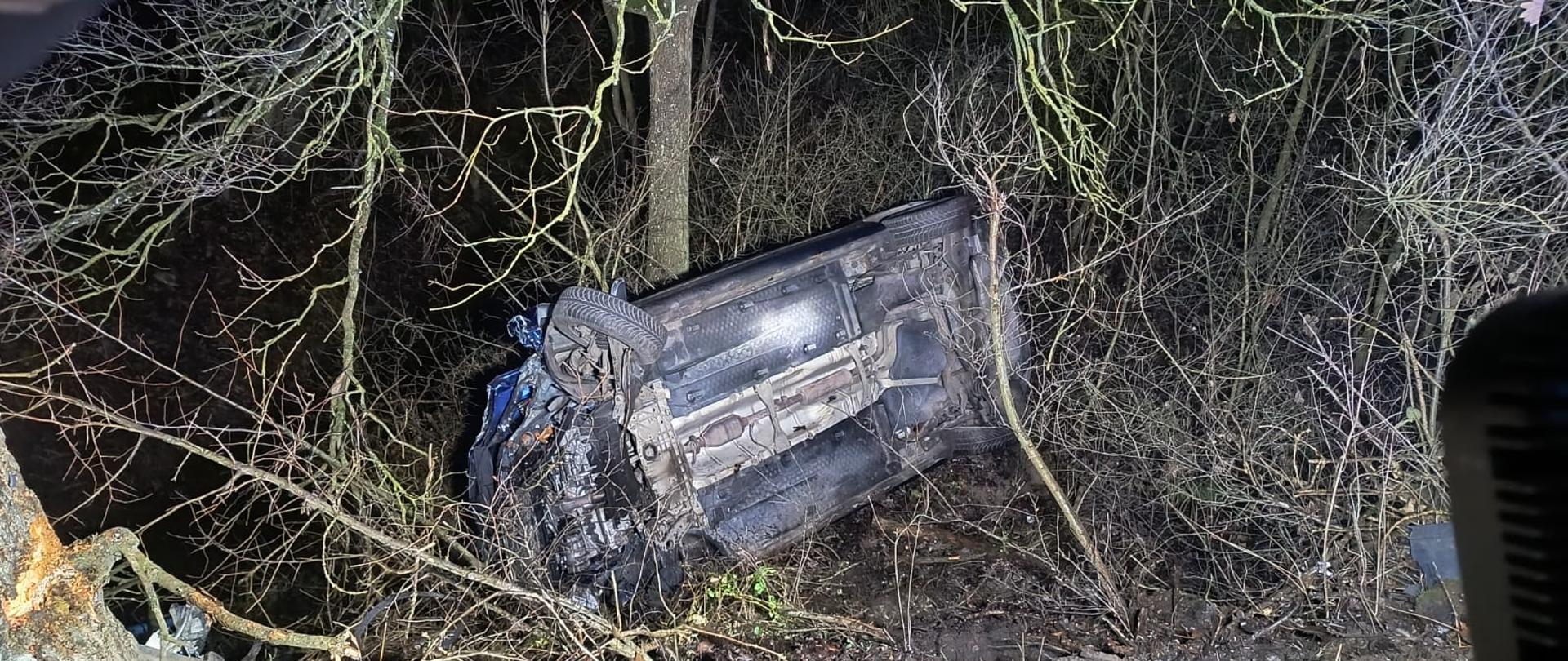 Ciemny samochód po dachowaniu w rowie, jest ciemno