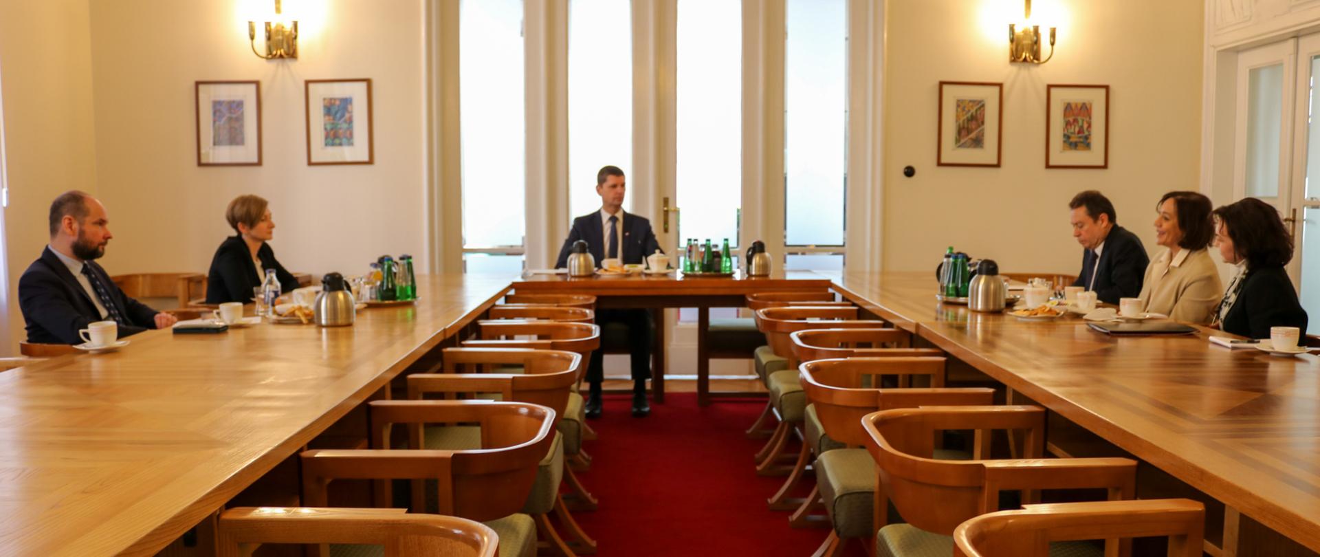 Uczestnicy spotkania siedzą za stołem.