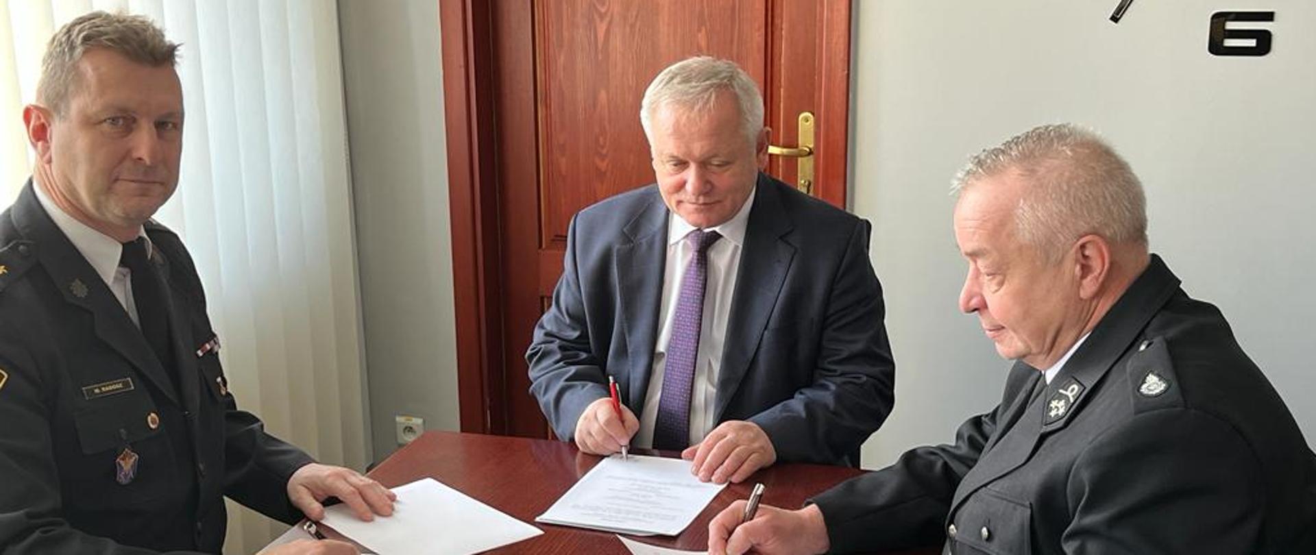 Na zdjęciu Komendant Miejski Państwowej Straży Pożarnej w Częstochowie  brygadier Marek Radosz, Wójt Gminy Mykanów Pan Dariusz Pomada, Prezes OSP Borowno druh Mariusz Wawrzak, podpisujący porozumienie w sprawie włączenia jednostki Ochotniczej Straży Pożarnej w Borownie do krajowego systemu ratowniczo – gaśniczego.