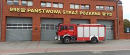 nowy samochód strażacki na tle budynku Komendy