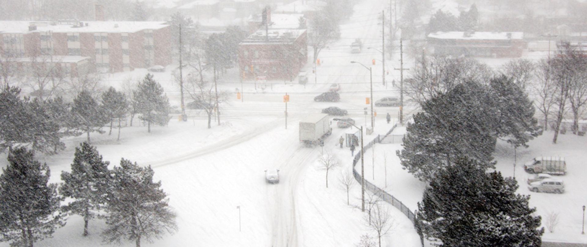 Na zdjęciu: część miasta - ulica i domy podczas opadów śniegu.
