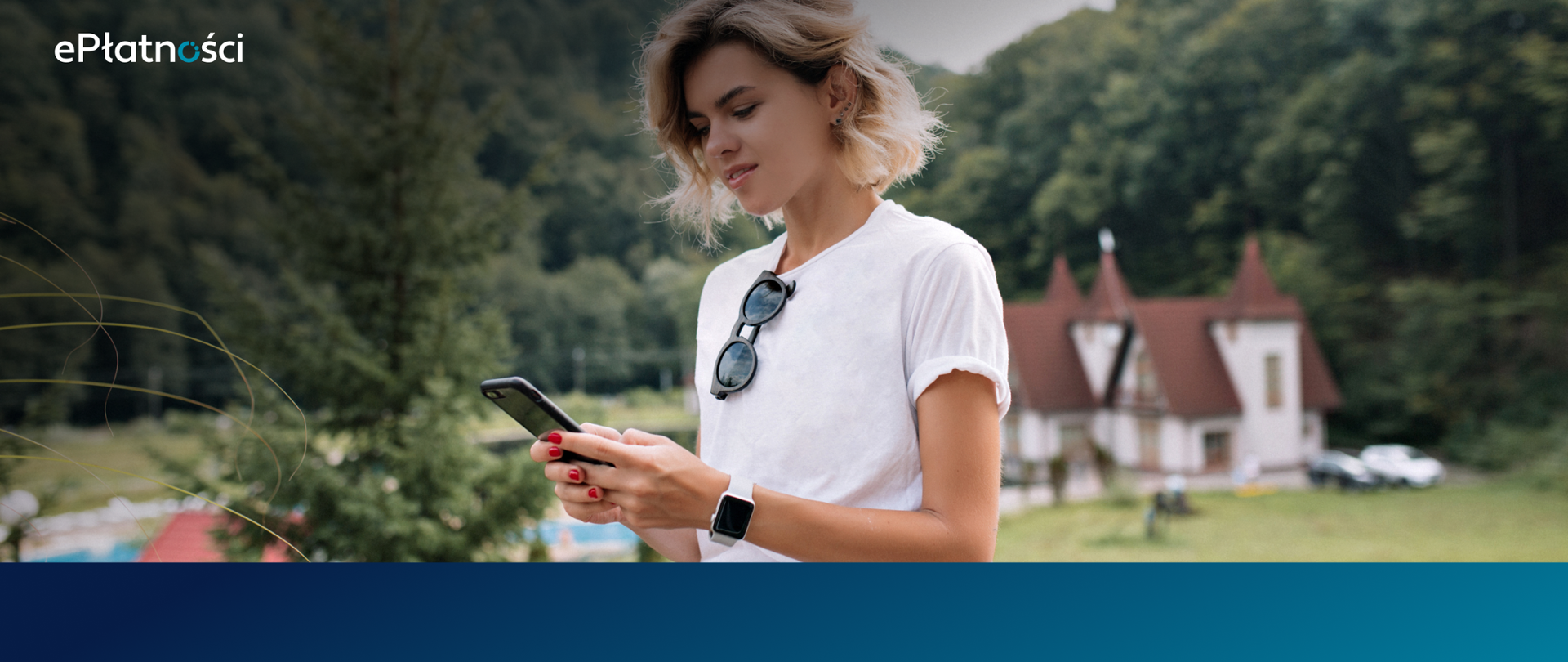Dziewczyna w białej koszulce trzyma telefon w dłoniach, w tle las i budynek