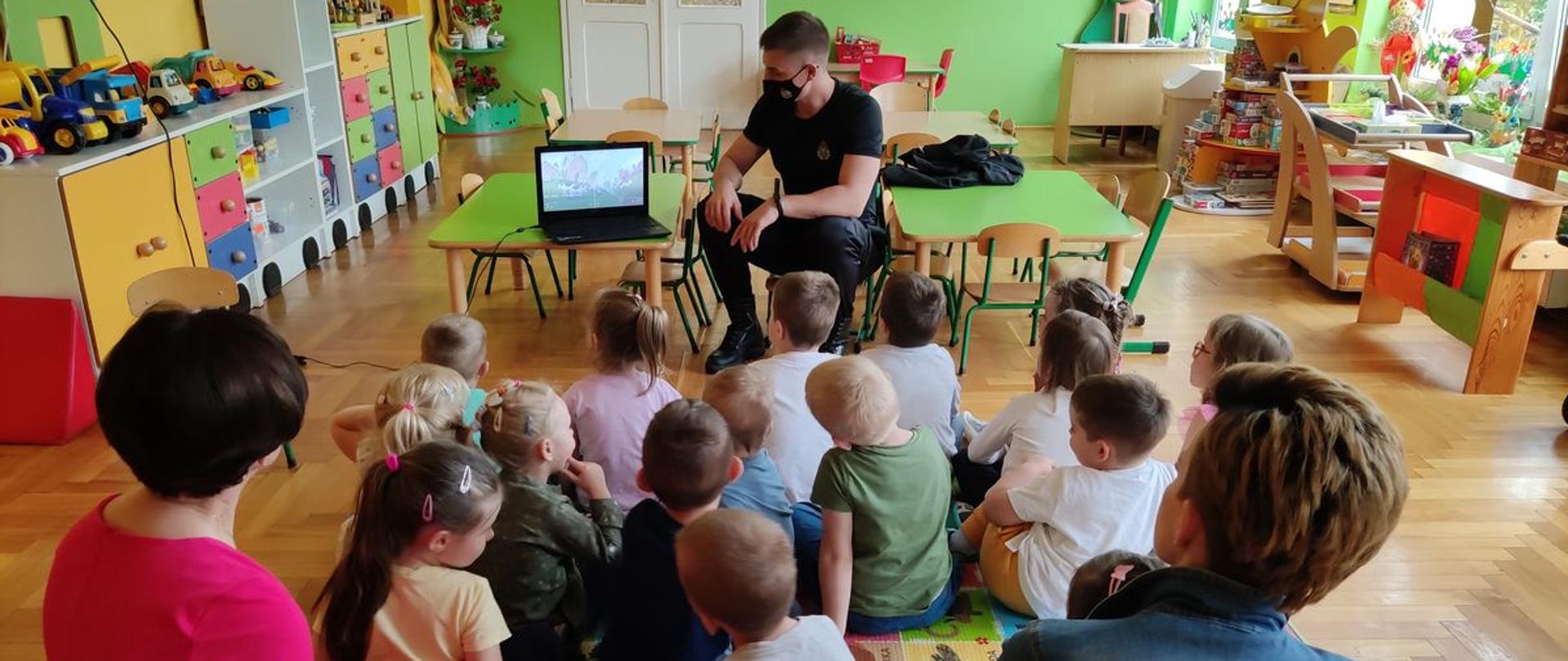  Zdjęcie przestawia funkcjonariusza Komendy Powiatowej Państwowej Straży Pożarnej w Radziejowie prezentującego informacje w tematyce zasad bezpieczeństwa pożarowego oraz związanych z akcją „STOP POŻAROM TRAW”