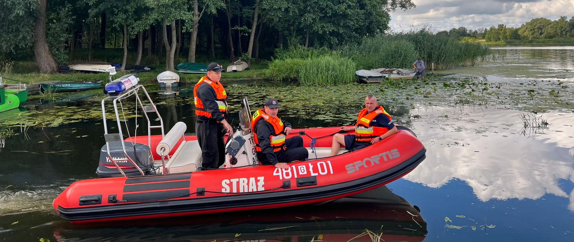Fotografia przedstawia dwóch funkcjonariuszy PSP Malbork oraz jednego funkcjonariusza KPP Policji w Malborku na łodzi motorowej.