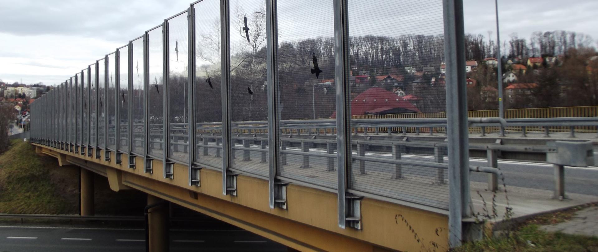 wiadukt nad drogą, na pierwszym planie przezroczyste ekrany z naklejonymi konturami ptaków