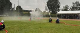 Ćwiczenie bojowe w wykonaniu damskiej drużyny ochotniczej straży pożarnej. Rota strąca pachołki prądem wody.