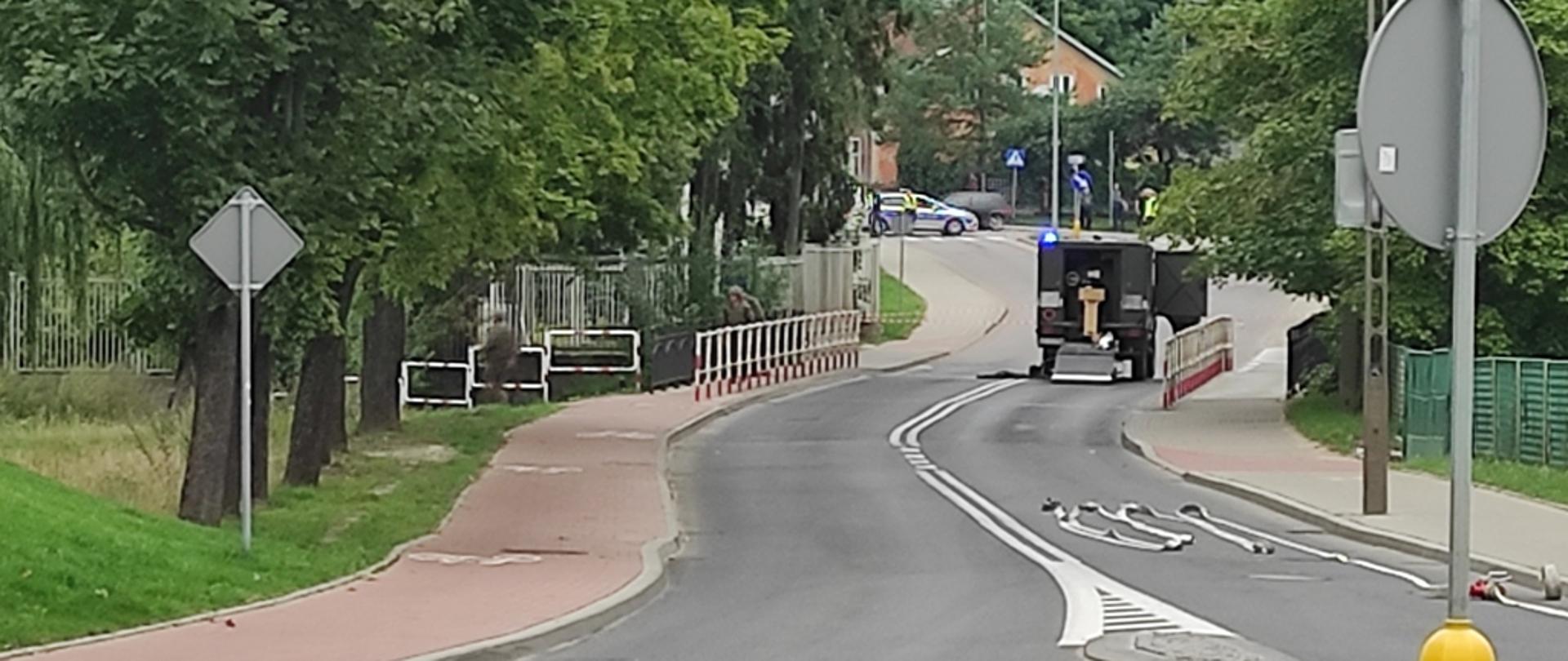 Na moście drogowym w ciągu ulicy Drwęckiej, w Ostródzie stoi patrol saperski. 
