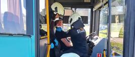 Zdjęcie przedstawia strażaków podczas próby ewakuacji poszkodowanego z autobusu