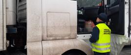 Inspektor wielkopolskiej Inspekcji Transportu Drogowego pobiera wymagane dokumenty od kierowcy ciężarówki, który nie zastosował się do obowiązującego zakazu tonażowego na jednej z głównych arterii na terenie Konina. 