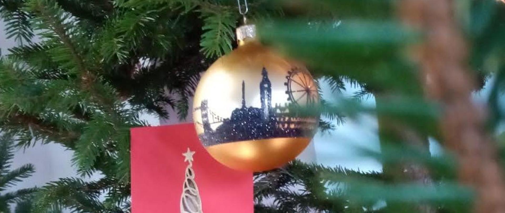 Zdjęcie złotej bombki na choince oraz kartki