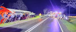 Zdjęcie przedstawia samochód cysternę oraz samochód osobowy po wypadku drogowym, karetkę pogotowia, oraz strażaków podczas działań ratowniczych