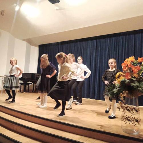 
Na zdjęciu grupa dzieci tańczy na scenie.
