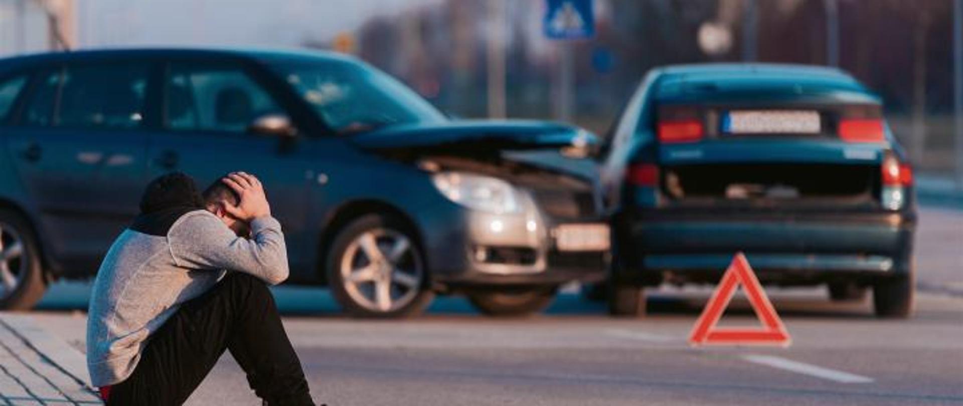 osoba poszkodowana siedzi na krawężniku