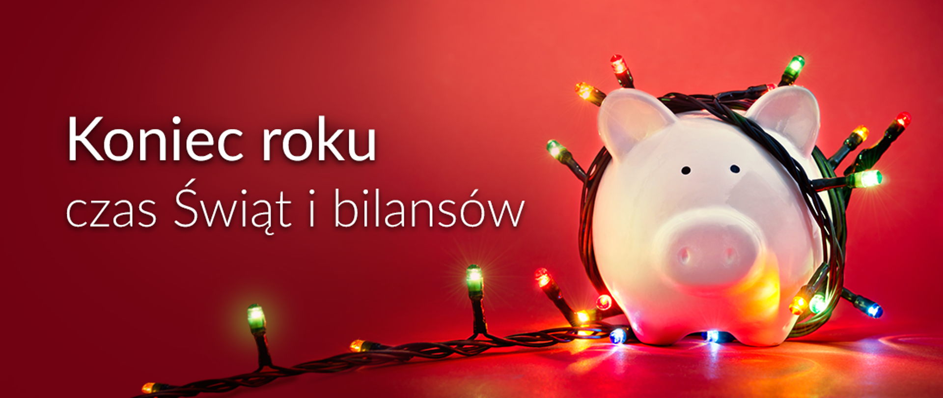 Świnka_skarbonka owinięta sznurem światełek choinkowych. Treść na banerze: Koniec roku czas świat i bilansów.