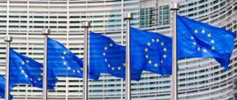 Flagi unijne przed budynkiem Komisji Europejskiej.