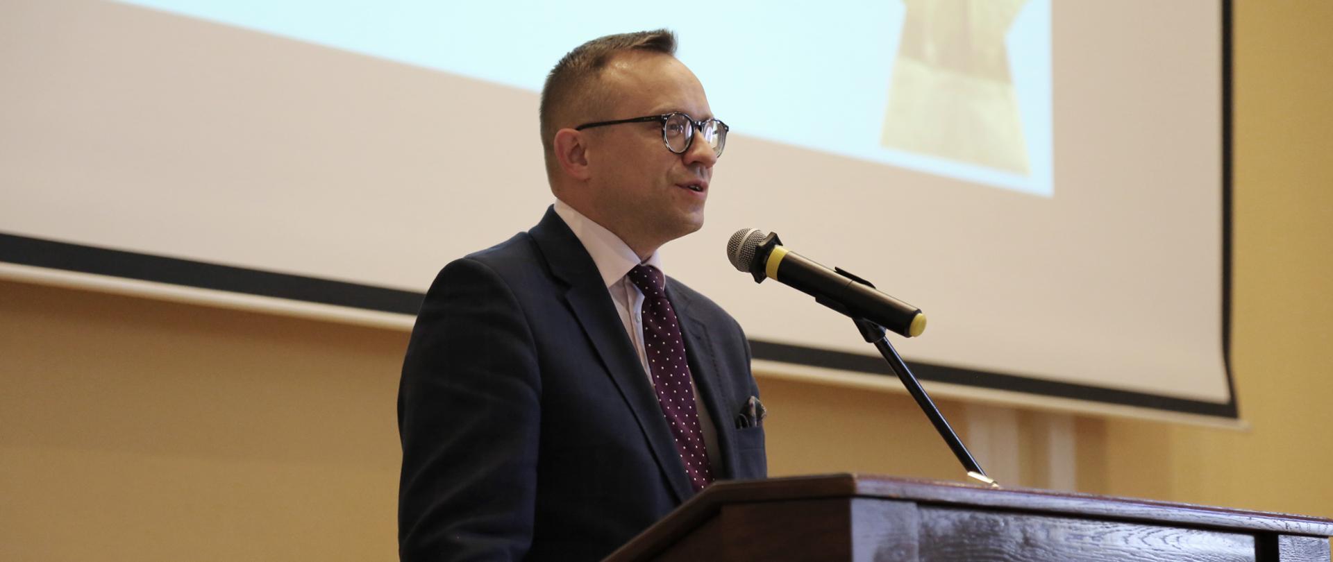 wiceminister mówi do mikrofonu