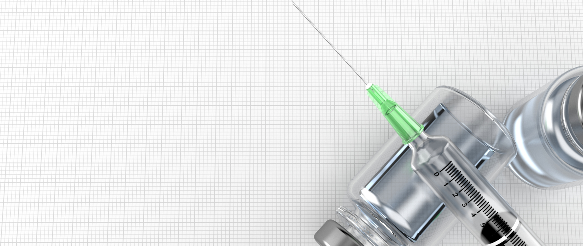 Dwie fiolki szczepionki, na których leży igła ze strzykawką. Materiały położone na kartce w kratkę