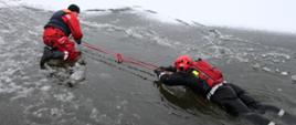 Zdjęcie przedstawia ćwiczących strażaków podczas ćwiczeń na lodzie