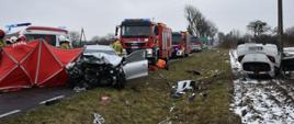 Na zdjęciu widać rozbite pojazdy osobowe, strażaków oraz wozy strażackie