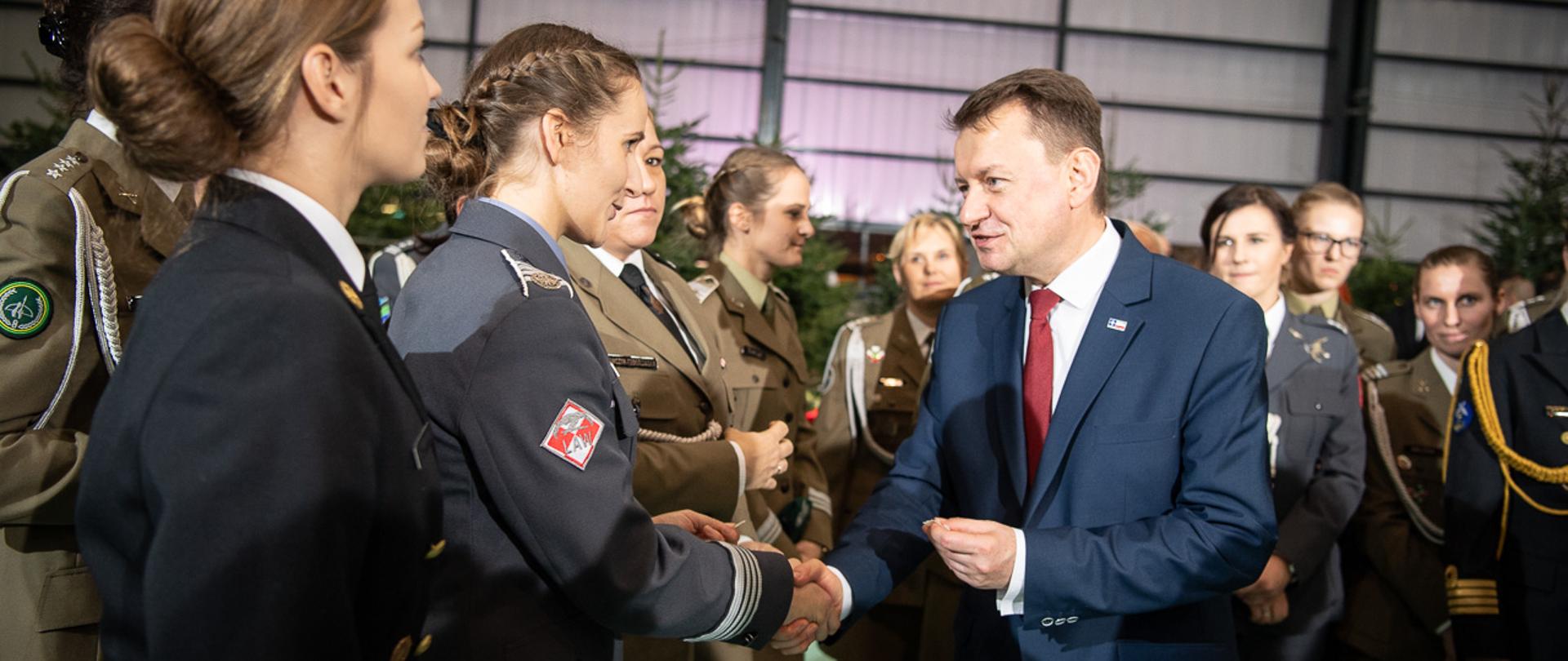 Minister Mariusz Błaszczak dzieli się opłatkiem z żołnierzami.