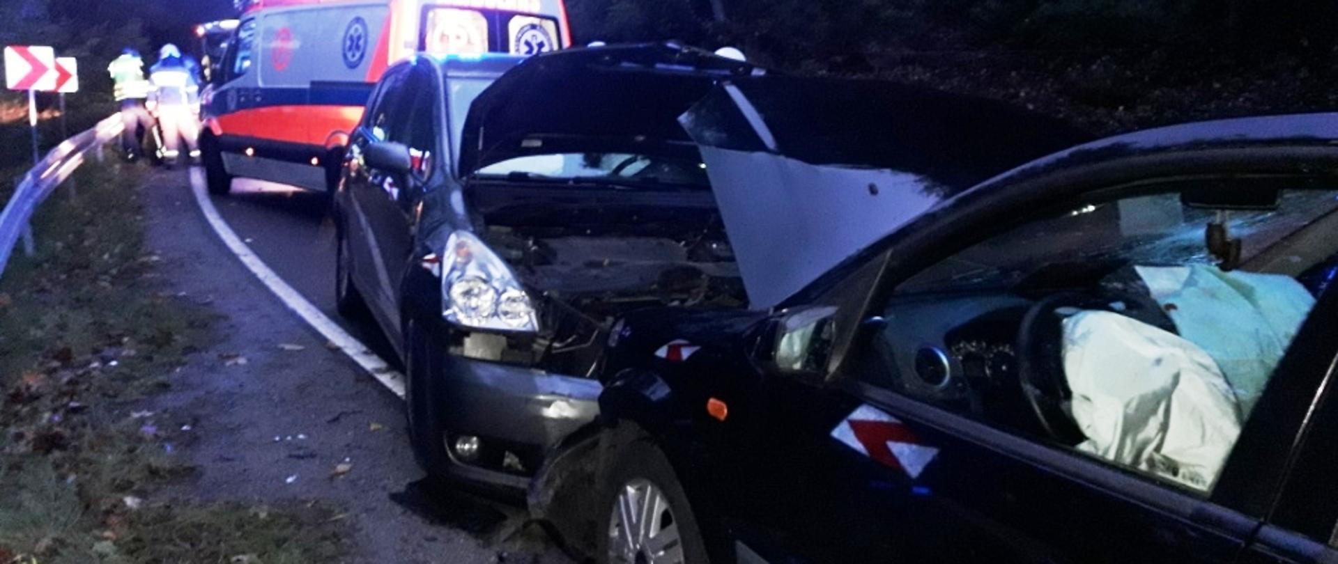 Samochody które się zderzyły stoją na środku drogi.