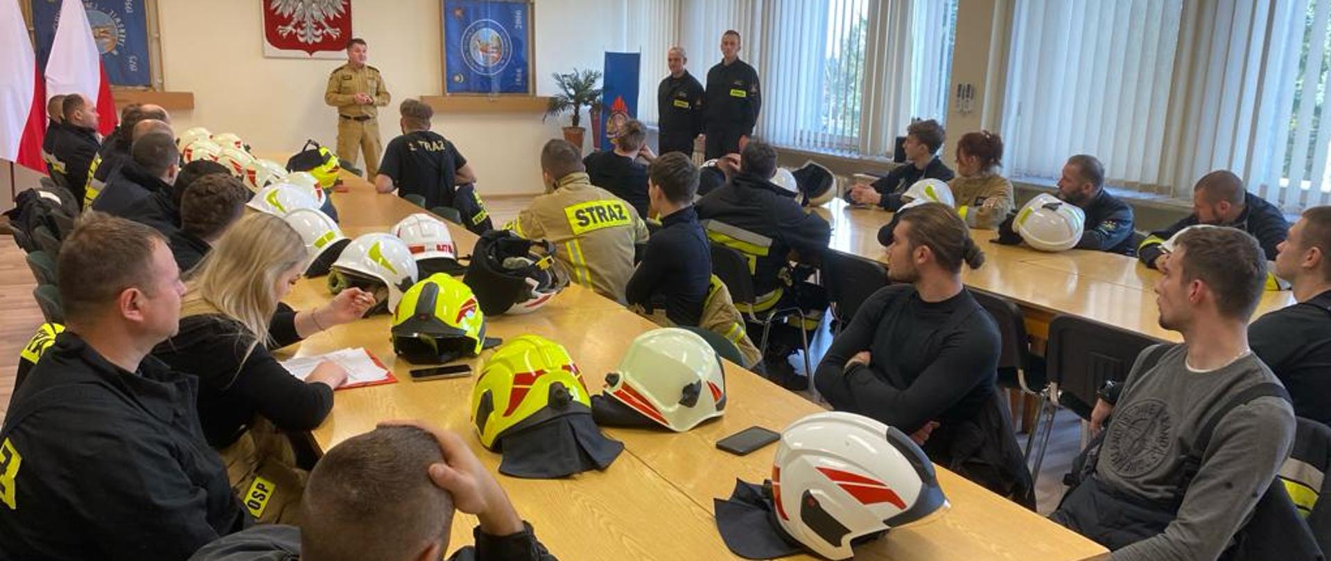 na zdjęciu widoczni druhowie po zakończonym egzaminie praktycznym w Sali szkoleniowej w trakcie przemowy Komendanta Miejskiego