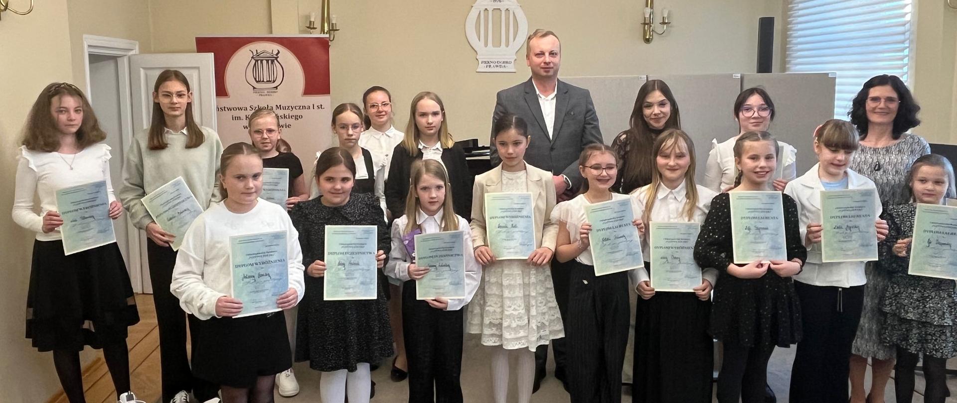 Uczennice trzymające dyplomy oraz Jury konkursu.